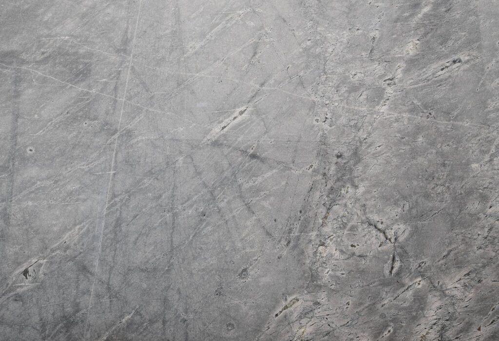 Close-up of a textured grey stone surface suitable for backgrounds or wallpapers.