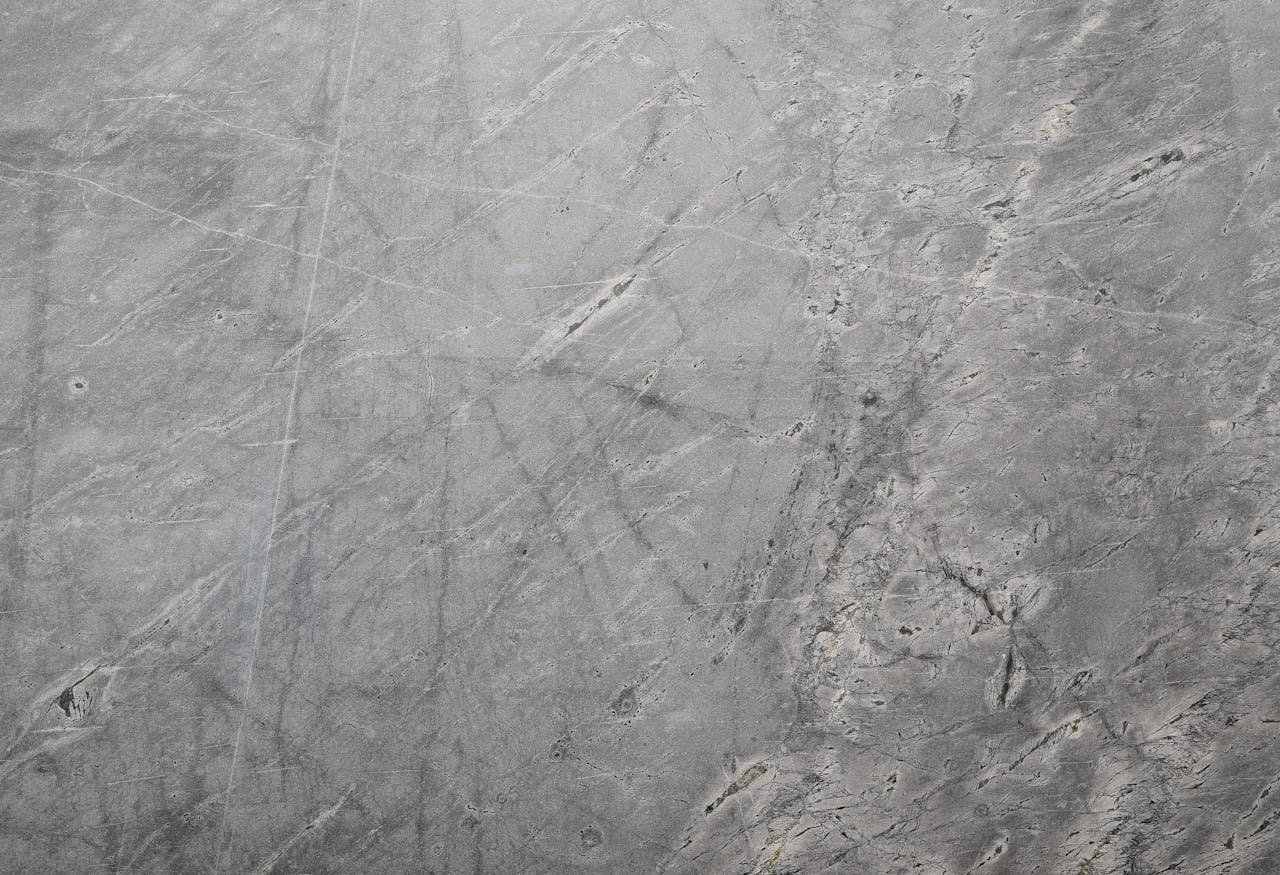 Close-up of a textured grey stone surface suitable for backgrounds or wallpapers.
